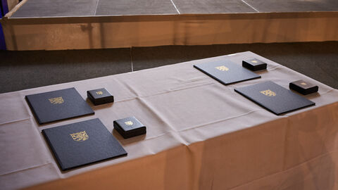 Die vier Medaillen und Urkunden liegen auf einem Tisch bereit