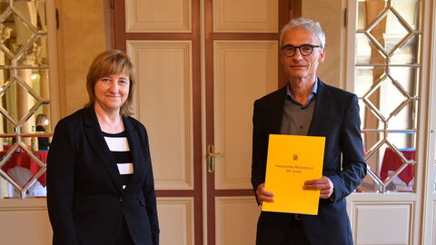 Justizministerin Eva Kühne-Hörmann mit Helmut Vogt, der seine Ernennungsurkunde in den Händen hält.