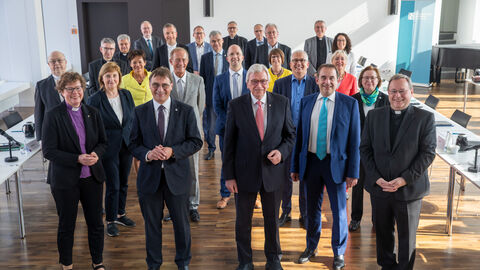 Die Hessische Landesregierung gemeinsam mit den Vertretern der Kirchen und Bistümer, alle lächeln in die Kamera.