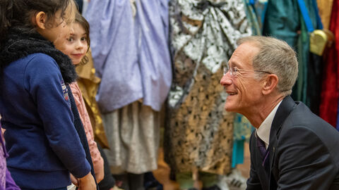 Staatsminister Wintermeyer vor einem Mädchen, er redet mit ihm auf Augenhöhe