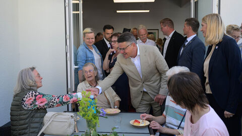 Ministerpräsident Boris Rhein begrüßt Besucherinnen des neuen Dorfhauses in Schmitten